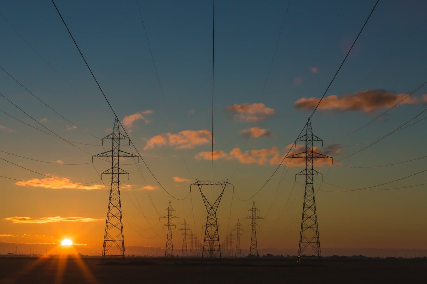 Electricity pylons and power lines at sunset