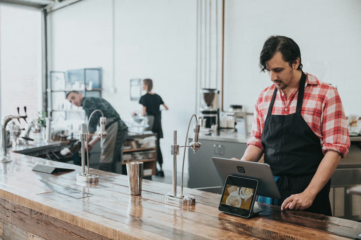 Barista using a tablet EPOS till at a café counter